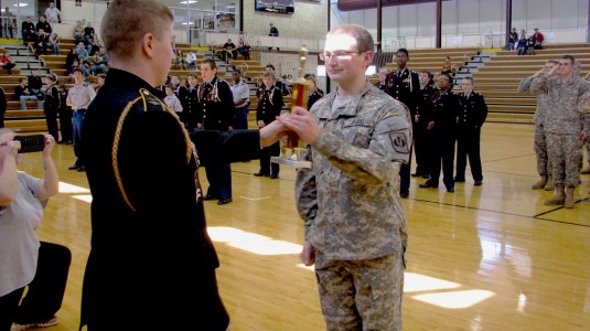 Cadet Capt. Jacob Belmar accepts the first place physical fitness challenge trophy from Cadet Lt. Col. Brandon Davis.