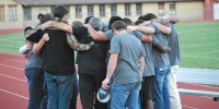 A group of youth and sponsors are huddled together at this years Fields of Faith in Poplar Bluff