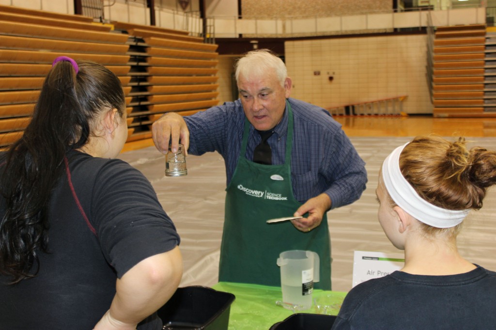 High school science teacher Vic Clark demonstrates surface tension “magic,” to the amazement of students.