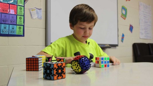 Gifted student Ethan Hudlow sets his timer in preparation to demonstrate how fast he can solve his favorite Rubik’s Cube in his collection, the standard 3x3x3 model.