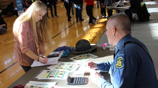 Jamie Hobbs, a PBHS senior, visits the ‘fun stuff’ table manned by Sgt. Clark Parrott of the Missouri State Highway Patrol, to select from entertainment activities including sports equipment, hobby supplies, movies, concert tickets and vacation packages. 