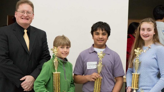 Regional Spelling Bee Coordinator Mark Sanders with this year's winners River Blount, 1st place, from Pineywoods Christian Academy in Annapolis; Justin Ray Samanta, 2nd place, of Trinity Lutheran School in Cape Girardeau; and Andrea DeYong, 3rd place of Immaculate Conception School in Jackson.