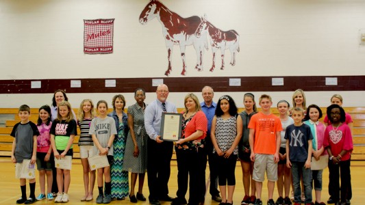 Accompanied by councilman Ed DeGaris, mayor Angela Pearson presents a proclamation to R-I Superintendent Chris Hon, who is joined by school board member Dr. Cynthia Brown. Also pictured during the honors assembly are teacher and student representatives from the 5th & 6th Grade Center.