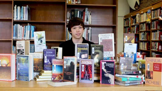 Poplar Bluff High School senior Ben Soeter surrounded by some of the books he's completed.