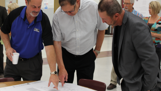 (Left to right) Architect Brett Dille goes over the site plan for the future high school with local businessmen, Herman Styles and Rick Lansford.