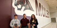 Poplar Bluff Mules Booster Club member Brian Taylor presents Zane Foust and Gracie King awards for AOM on Tuesday, Oct. 25, in the gymnasium.